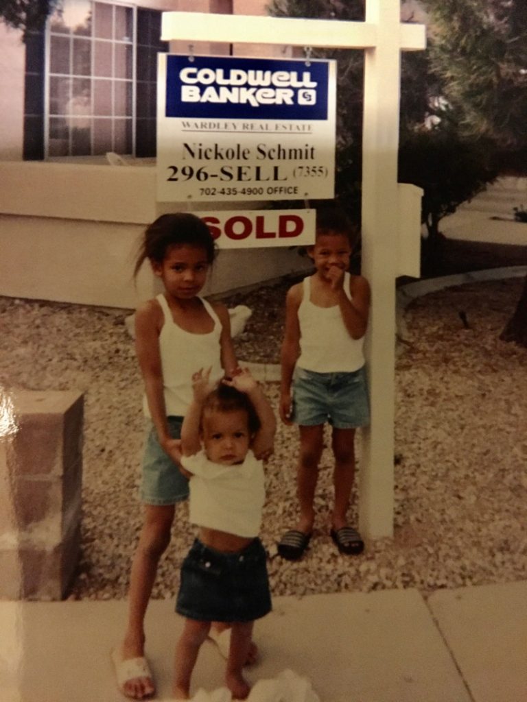 Three kids standing near a sign